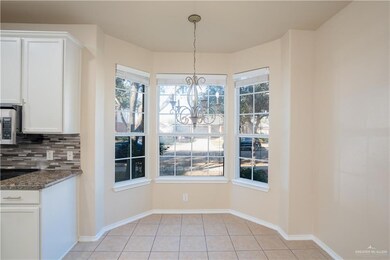 Featuring light tile patterned floors, a wealth of natural light, and an inviting chandelier