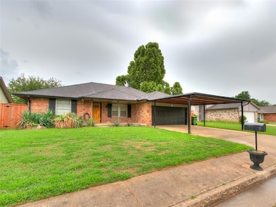 View of front of property featuring a garage, brick siding, concrete driveway, roof with shingles, and an attached carport