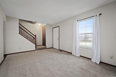 Stairs leading to 2nd level, coat closet at bottom