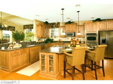 Kitchen. This Kitchen is unbelievable. Large Triangular Island with a sink located on the island. Gourmet Kitchen with gas cook-top, double ovens, microwave, disposal, wine cooler & additional compact refrigerator. Granite Tops & additional cabinetry.
