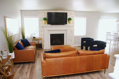 Living room with a large fireplace and wood finished floors