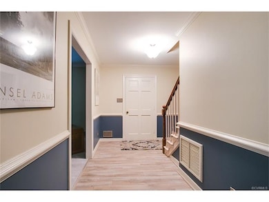 Foyer has updated laminate flooring and light fixt