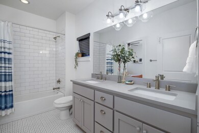 Bathroom featuring double vanity, shower / bath c