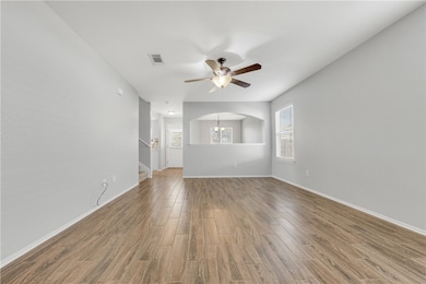 Unfurnished living room featuring stairway, a ceil