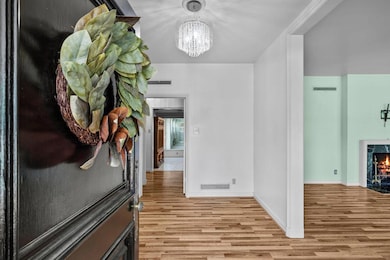 Corridor with wood finished floors, a chandelier,