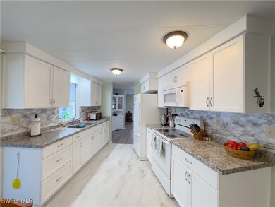 Kitchen featuring white appliances, white cabinets