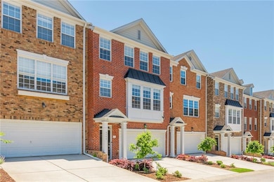 Multi unit property featuring brick siding, an attached garage, concrete driveway, and a residential view