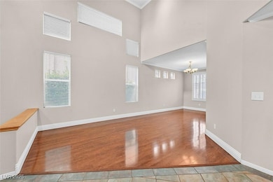 Spare room featuring a chandelier, wood finished f
