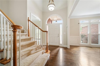 Entrance foyer featuring stairs, dark wood-type fl