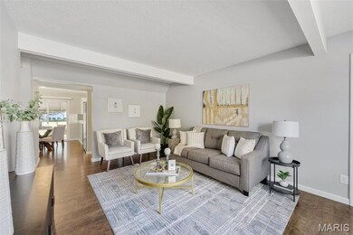 Living area with beamed ceiling, wood finished floors, and a textured ceiling