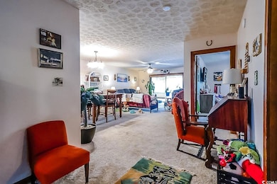 Carpeted dining area featuring ceiling fan