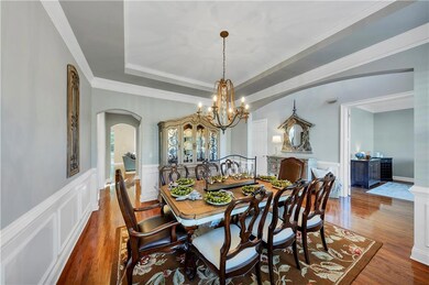 Dining space with wood finished floors, a raised c