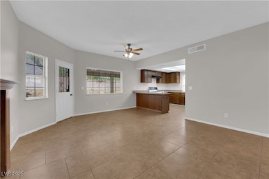 Unfurnished living room with a ceiling fan, plenty of natural light, and light tile patterned flooring