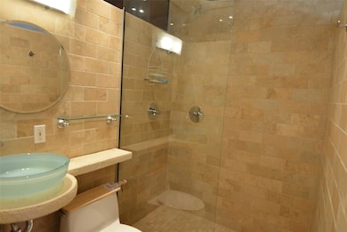 Full bathroom with a tile shower and toilet
