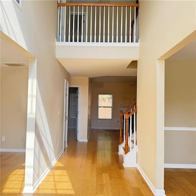 Entrance foyer with baseboards, a high ceiling, wo
