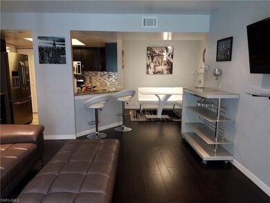 Remodeled living area with hardwood floors through