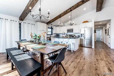 Dining area featuring beamed ceiling, light wood-style flooring, a chandelier, high vaulted ceiling, and recessed lighting