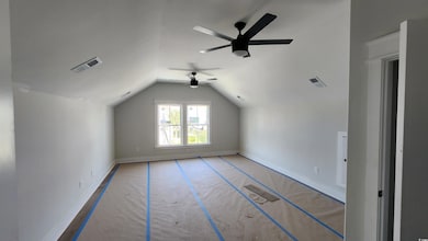 Bonus room with a ceiling fan, lofted ceiling, and baseboards