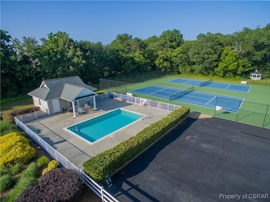 Community pool featuring a tennis court, a patio area, a storage structure, an outbuilding, and fence