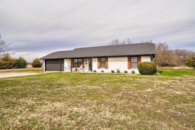 Ranch-style house featuring a front lawn and a gar