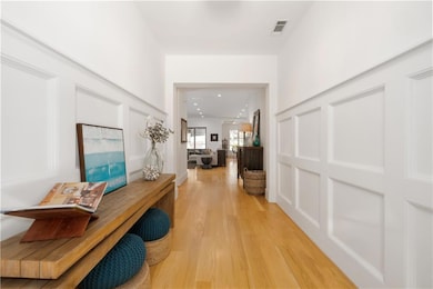 Hall with light wood-style floors and recessed lighting