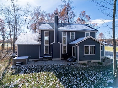 Rear view of house featuring a chimney, a hot tub, and entry steps