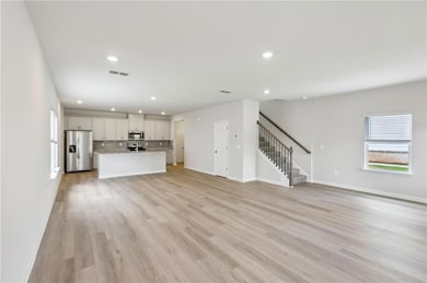 Unfurnished living room with stairway, recessed li