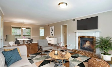 Living room with a brick fireplace, hardwood / woo