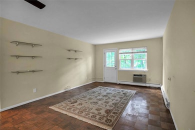Unfurnished room featuring baseboard heating and a ceiling fan