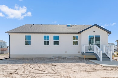 Back of property featuring a shingled roof and a patio