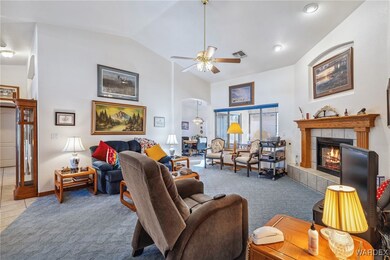 Tiled living room with ceiling fan, lofted ceiling