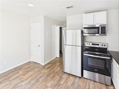 Kitchen with stainless steel appliances, light woo