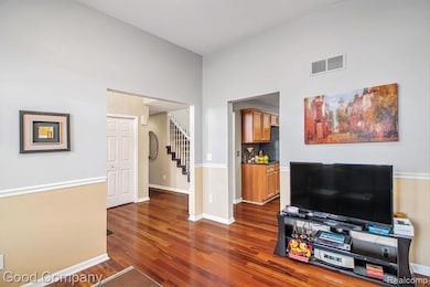 Living area featuring stairway, dark wood-type flooring, and a towering ceiling