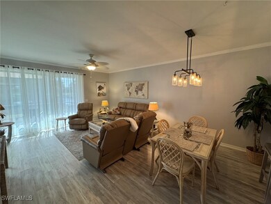 Living room with crown molding, ceiling fan with n