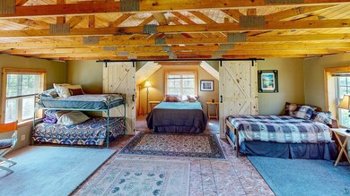 Bedroom featuring a barn door and vaulted ceiling 