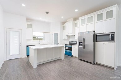 Kitchen with a center island, white cabinetry, stainless steel appliances, and light countertops