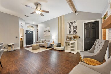 Living room with a ceiling fan, dark wood-style f