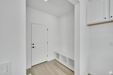 Mudroom featuring light wood-style flooring and baseboards