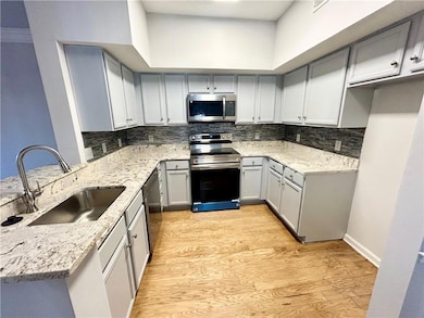 Kitchen with stainless steel appliances, sink, lig