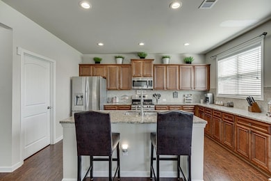 Kitchen with a kitchen bar, visible vents, stainle