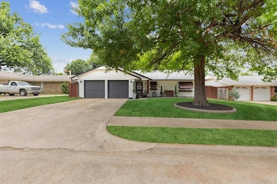 Ranch-style home with an attached garage, concrete driveway, and a front lawn