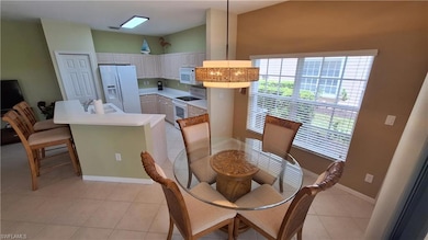 Dining room featuring light tile patterned floors and lofted ceiling