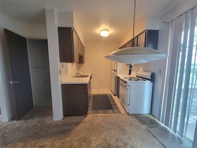 Kitchen view from Dining area of 1/2 Bath & Kitchen w/ Sliders to Patio
