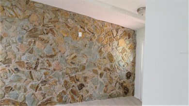 stone wall off of entrance to living area.