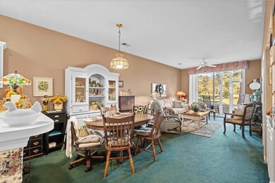 Carpeted dining room featuring ceiling fan