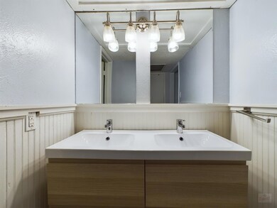 Bathroom featuring a wainscoted wall, a sink, and