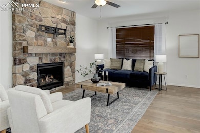 Living room with ceiling fan, baseboards, wood fin
