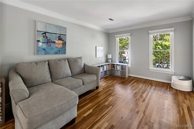 Living room featuring ornamental molding and hardw