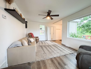 Living room with wood finished floors and a ceiling fan