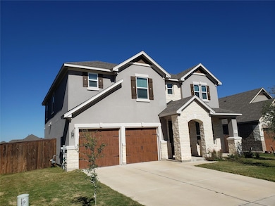 View of front of property with stone siding, stucco siding, a shingled roof, and driveway